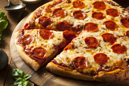Whole pepperoni pizza with one slice cut